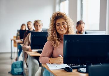 WOMAN IN COMPUTER CLASSROOM SMILING